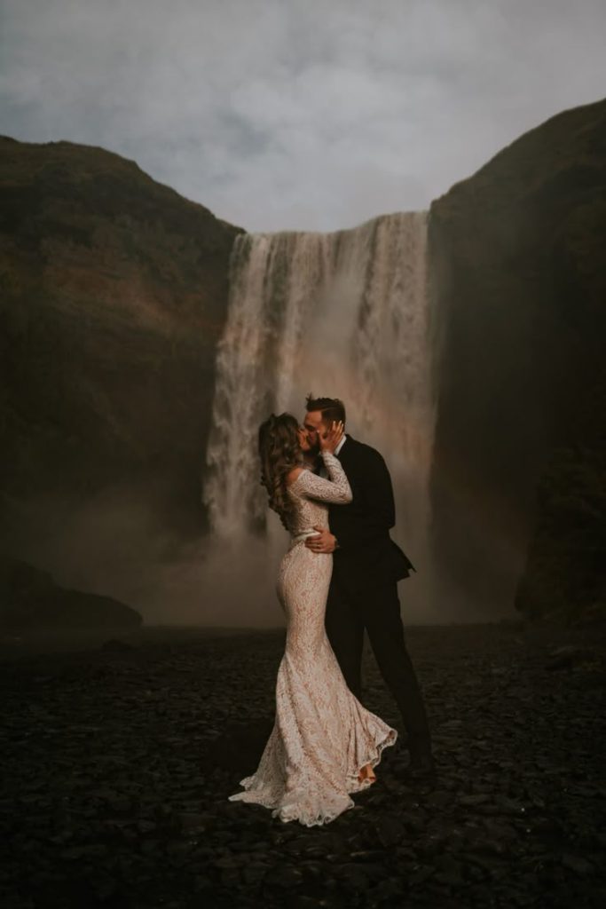 Iceland wedding, newlyweds kissing in front of a fosset