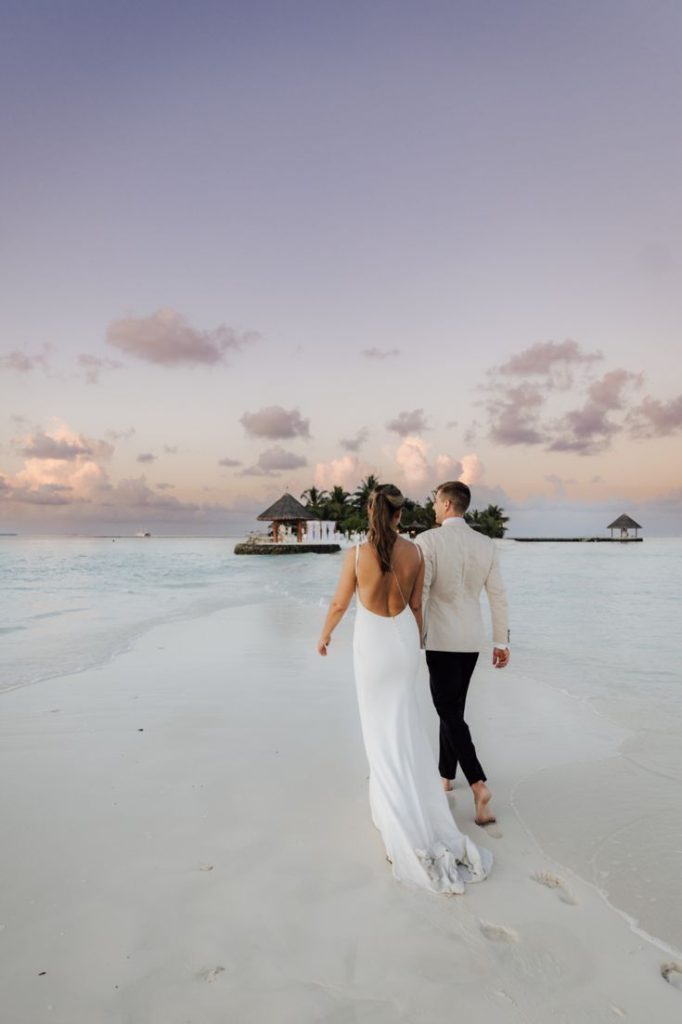 wedding couple at the maldives , walking on the beach